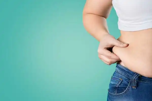 Image of woman pinching her love handles to show weight gain Royal Leamington Spa